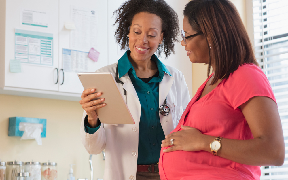 A doctor discussing exam with pregnant patient