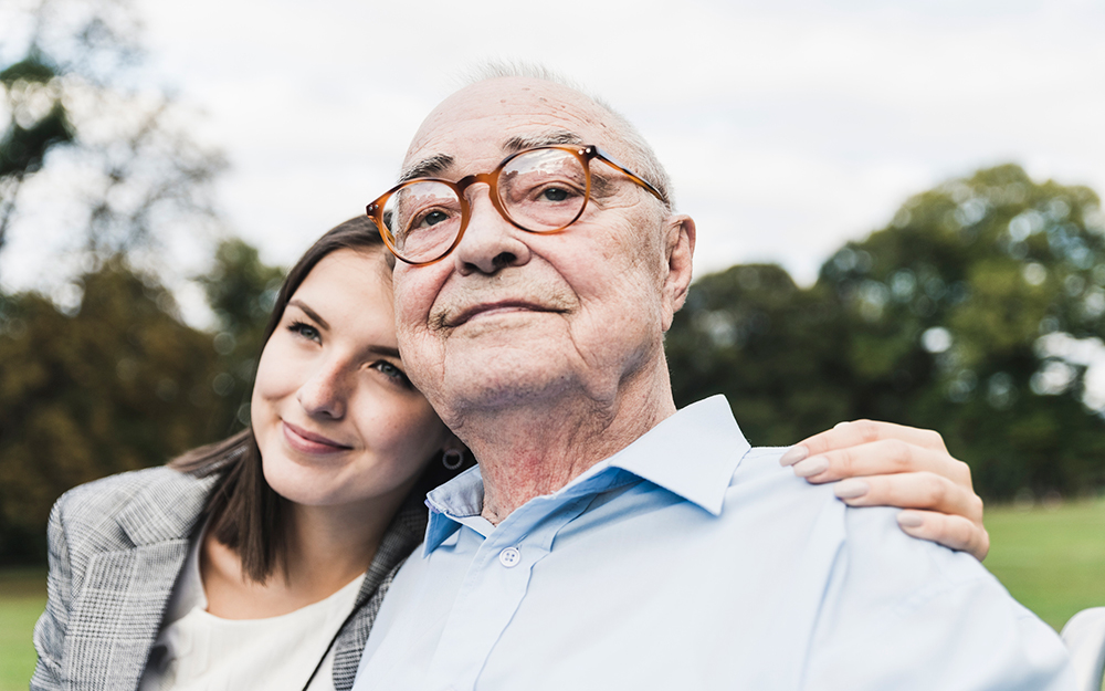 Woman with her arm around elderly man