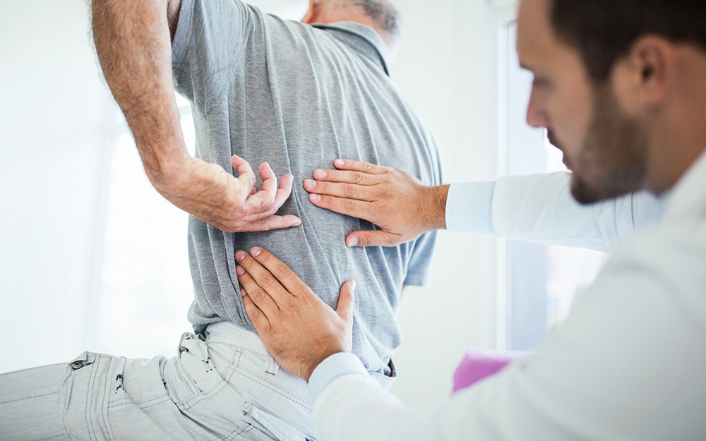 Doctor examining man's back