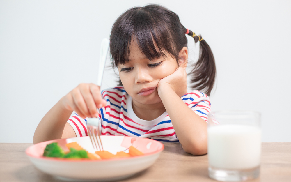 Little girl playing with her food