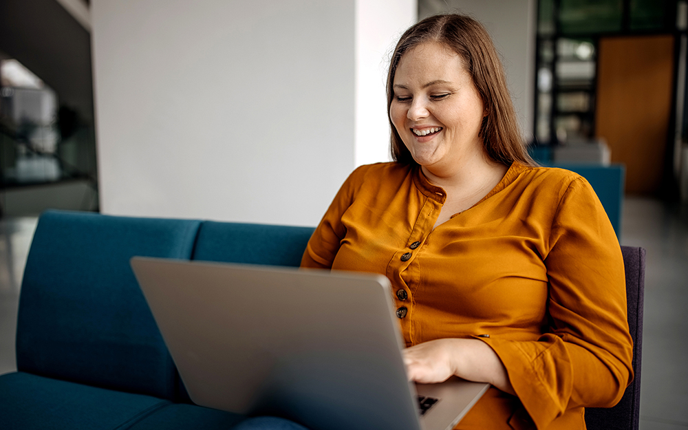 Young woman working in cafeteria on laptop