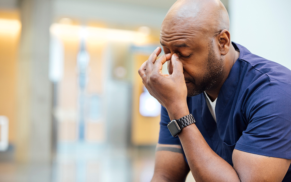 Healthcare worker holding his head