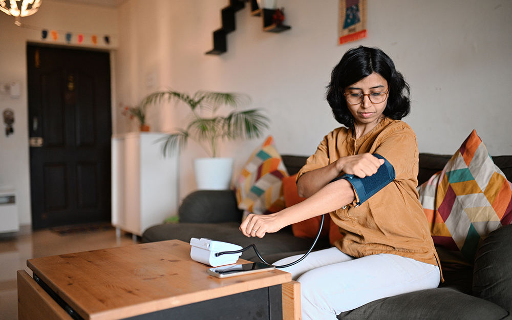 Woman taking blood pressure at home