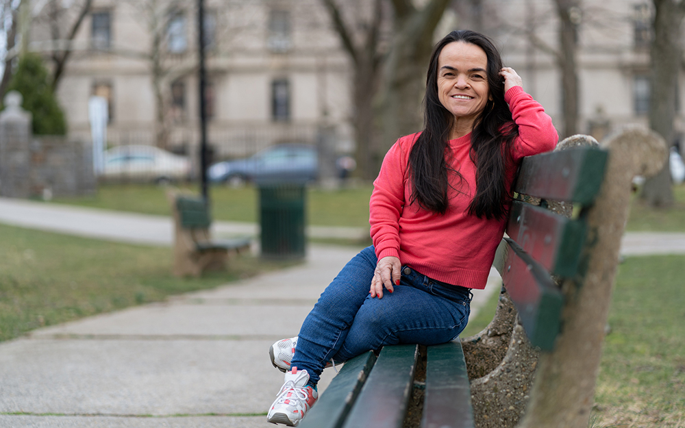 Little woman sitting on a park bench