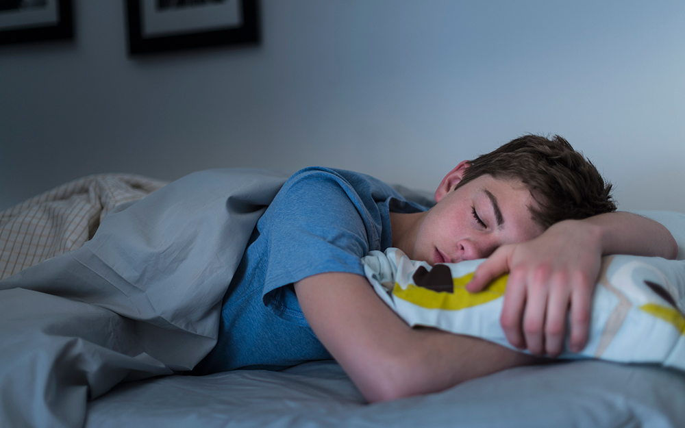 Teen boy sleeping in bed