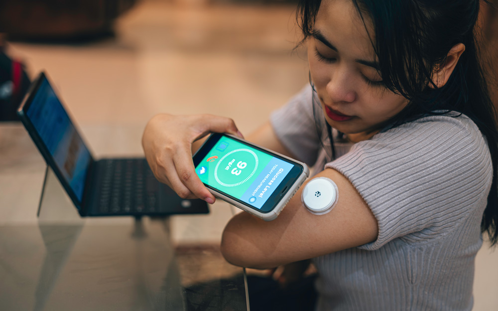 A woman measuring her glucose through aa glucose monitor