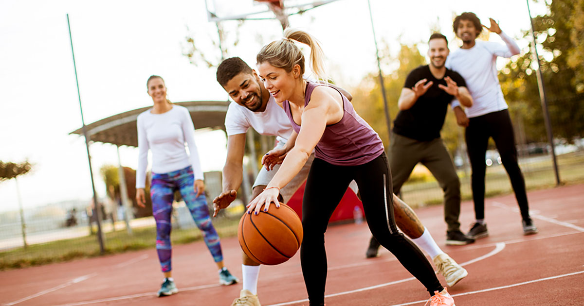 Group of men and women playing basketball.