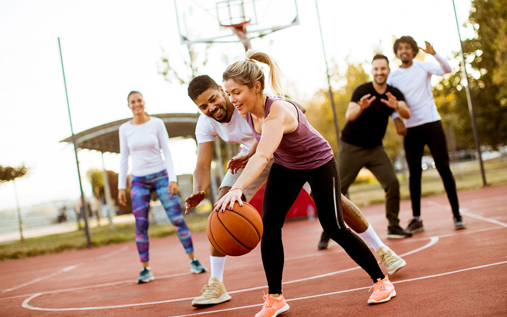 Group of men and women playing basketball.