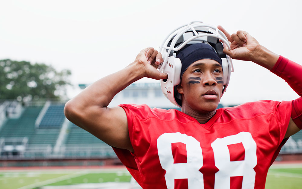 Football player taking his helmet off.