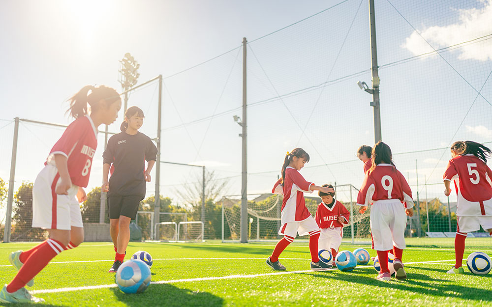Group of girls practicing soccer on a field.