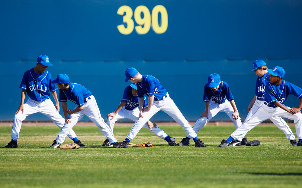 Little league baseball team stretching.