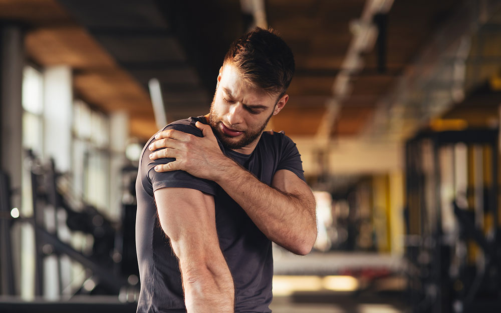 Man holding onto his shoulder in pain.