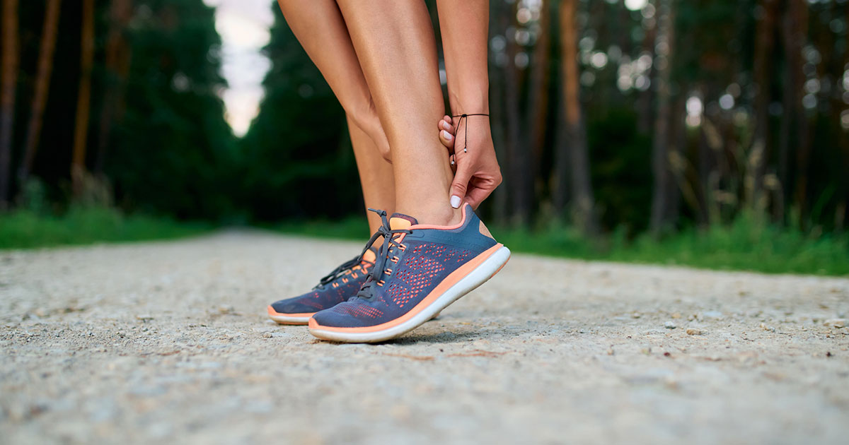 Woman holding her achilles tendon.
