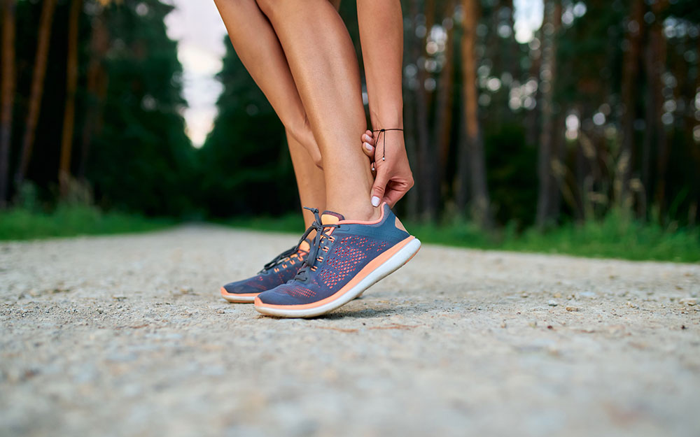 Woman holding her achilles tendon.