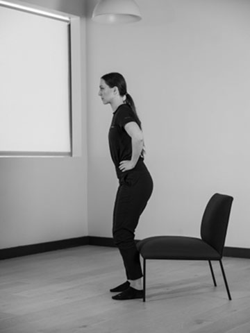 Woman standing up from chair.
