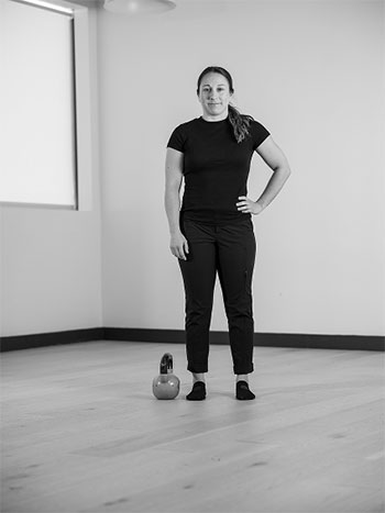 Woman standing with one arm on her side.