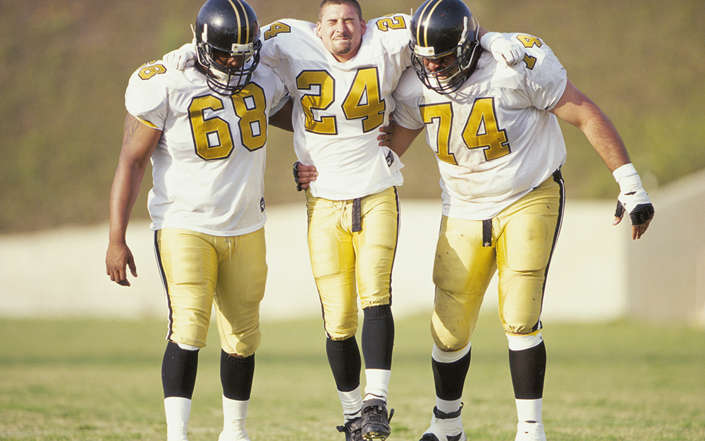 Injured football player being helped off the field.