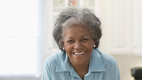 Older African American woman smiling in kitchen