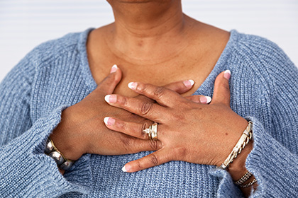 Woman with hands over chest