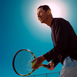 Man holding a tennis racket and ball.