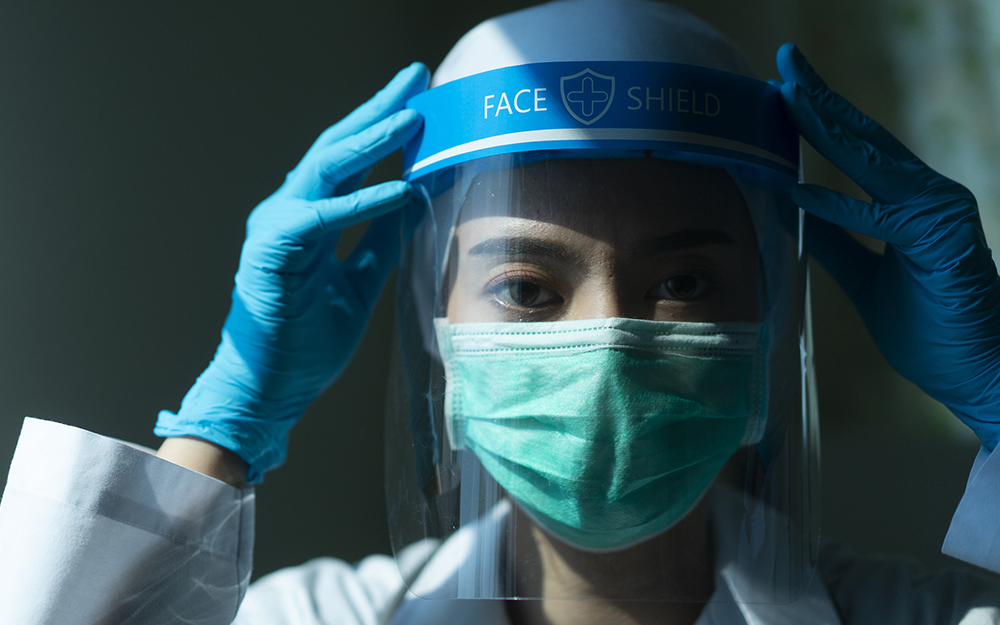 Woman doctor with shield and glove.