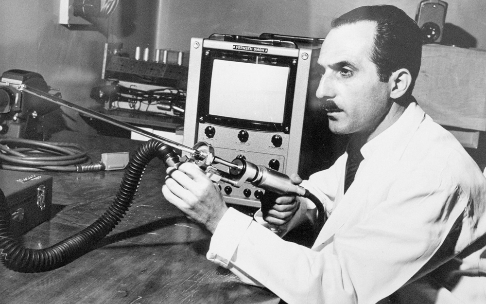 A black and white photo of Dr. George Berci in 1962 with his video bronchoscope invention.