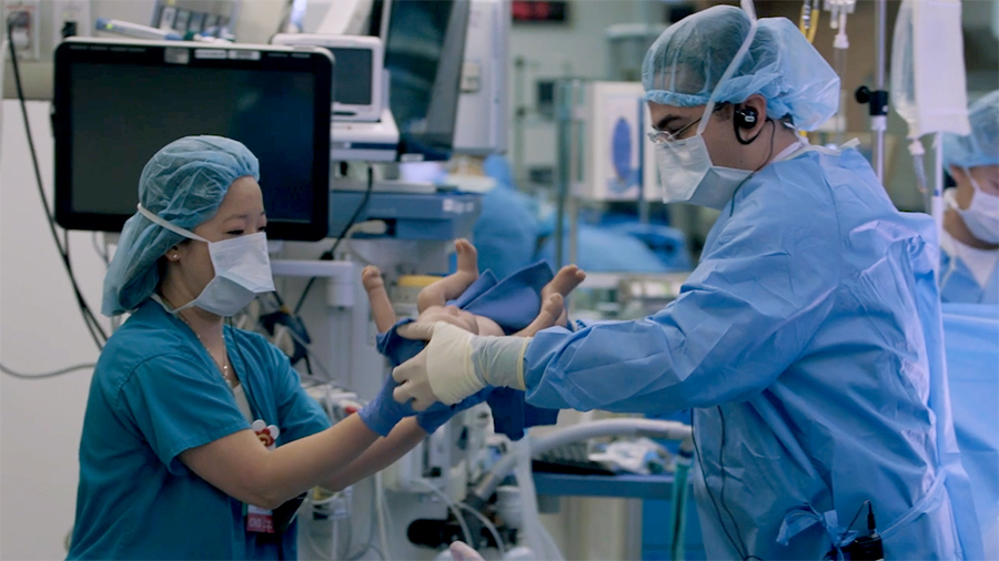 Surgical fellows handling baby dummy during surgical training at Cedars-Sinai Simulation Center, Training at Cedars-Sinai