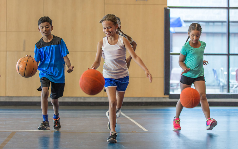 Multi-ethnic kids dribbling basketballs