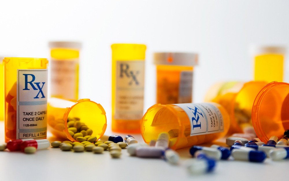 Disorganized pill bottles spilling medications onto a table.