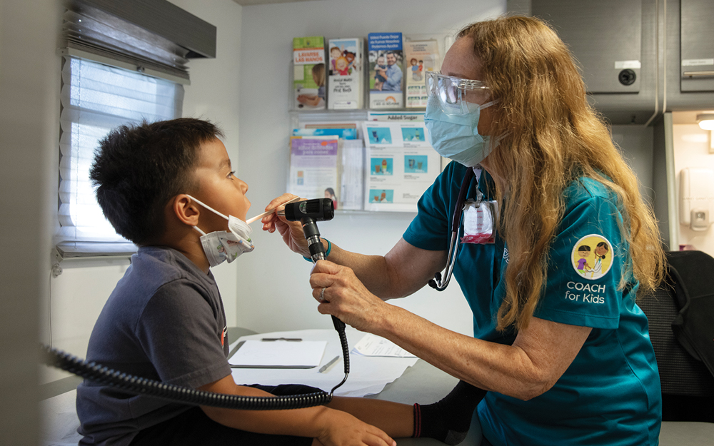 COACH for Kids healthcare provider checking a young boy in the mobile doctors office RV.