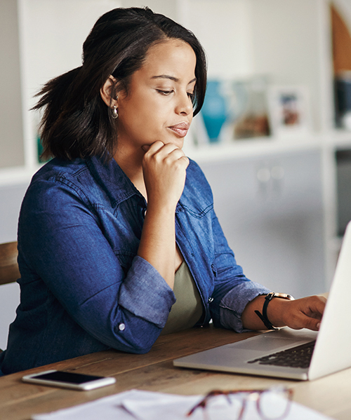 Shot of a young woman using a laptop while working from home