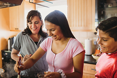 Minerva Quezada cooking with her children