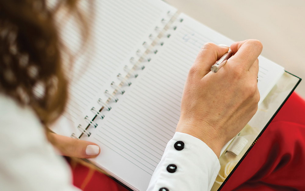 Woman writing in a notebook.