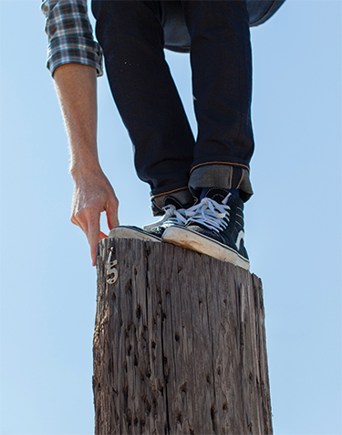 Man balancing on tree stump