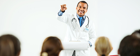 Group of doctors on a seminar. The focus is on cheerful  African-American man giving a speech.